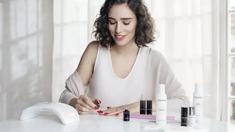 Mujer aplicando en uñas producto marca 'Neonail'